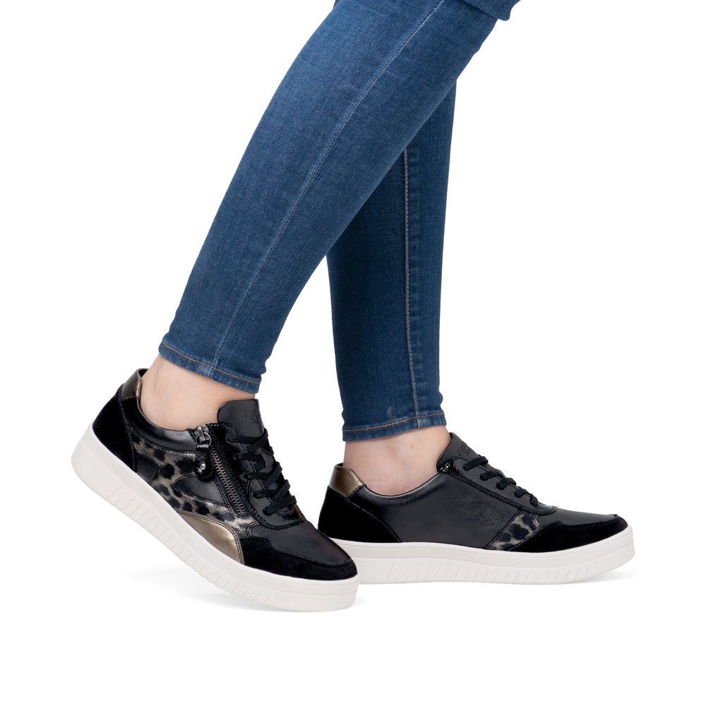 Night black remonte women´s sneakers D0J04-03 with animal print as well as a zipper. Shoe on foot.