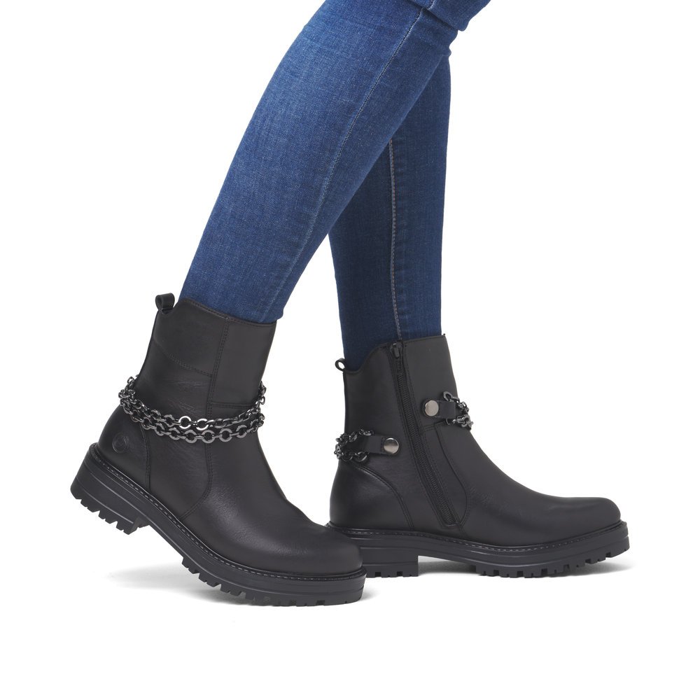 Black remonte women´s ankle boots D2285-00 with detachable chain as well as zipper. Shoe on foot.