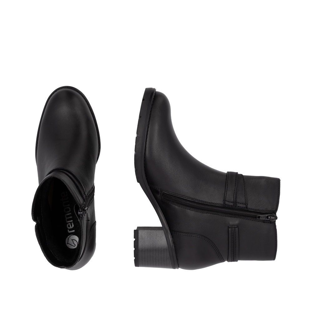 Jet black remonte women´s ankle boots D2A73-00 with a round decorative buckle. Shoe from the top, lying.