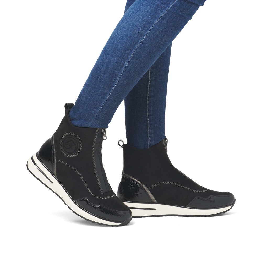 Tiefschwarze vegane remonte Damen Kurzstiefel D1G70-03 mit Zickzack-Nähten. Schuh am Fuß.