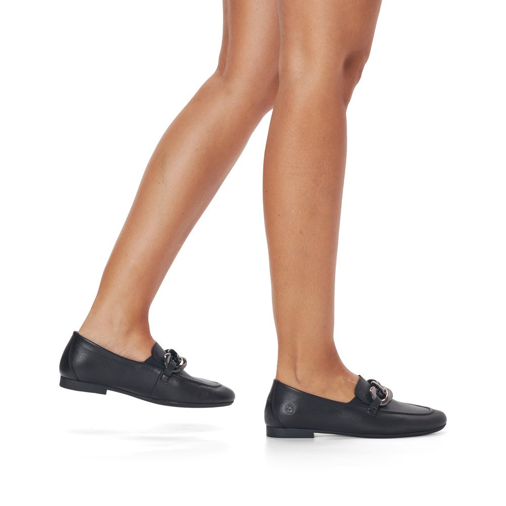Schwarze remonte Damen Loafer D0K00-00 mit Elastikeinsatz sowie stylischer Kette. Schuh am Fuß.