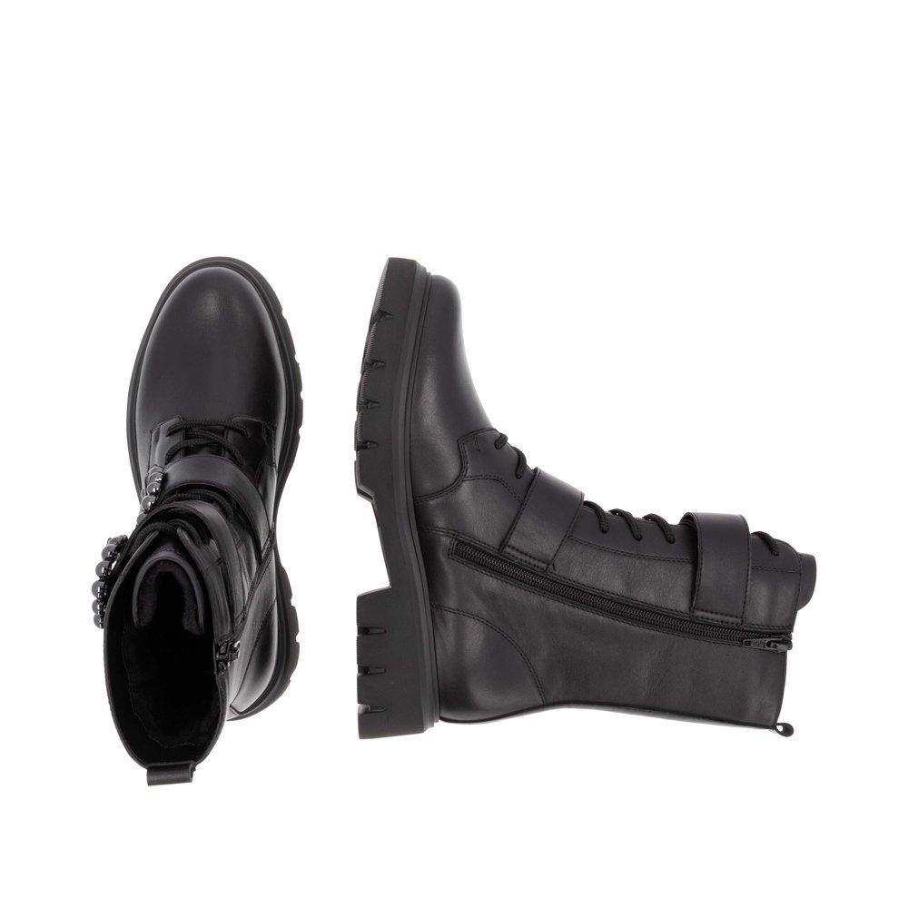 Jet black remonte women´s biker boots D1W70-00 with a round decorative buckles. Shoe from the top, lying.