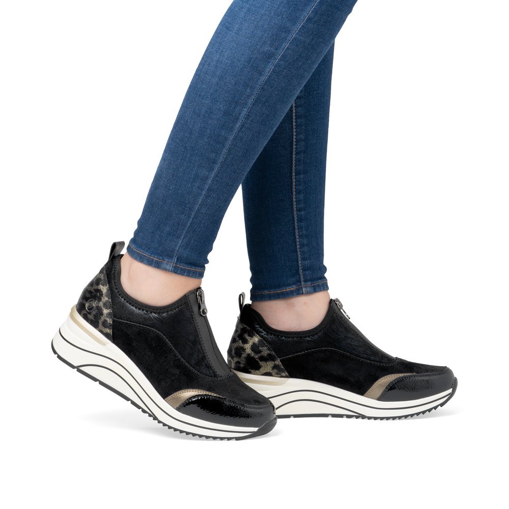 Black vegan remonte women´s sneakers D0T08-02 with animal print as well as a zipper. Shoe on foot.