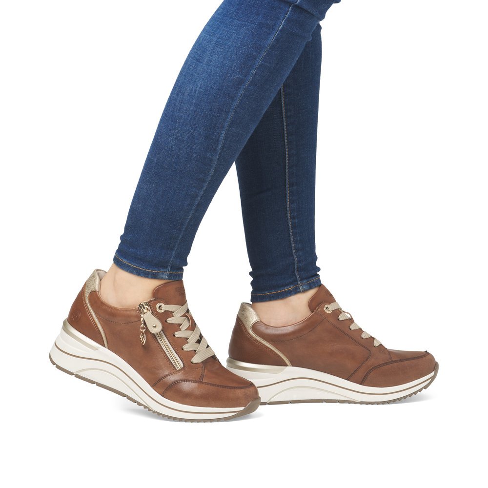 Brown remonte women´s sneakers D0T03-24 with a remonte pendant as well as a zipper. Shoe on foot.