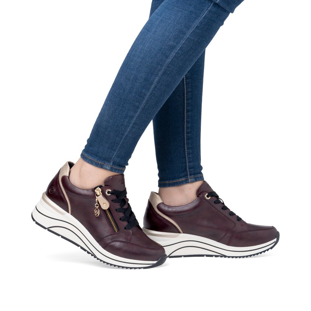 Maroon remonte women´s sneakers D0T03-35 with a remonte pendant as well as a zipper. Shoe on foot.