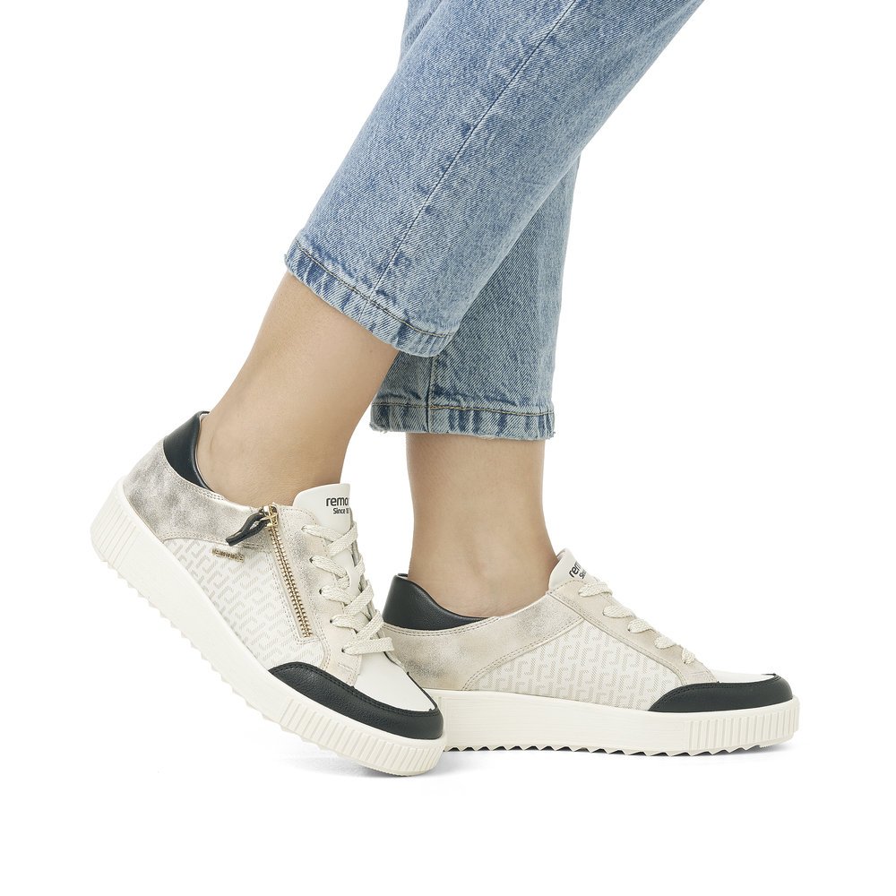 Cream white remonte women´s sneakers R7901-80 with a zipper and graphical pattern. Shoe on foot.