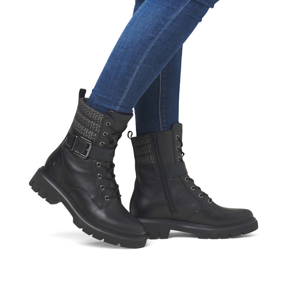 Black remonte women´s biker boots D1W71-03 with decorative buckle as well as zipper. Shoe on foot.