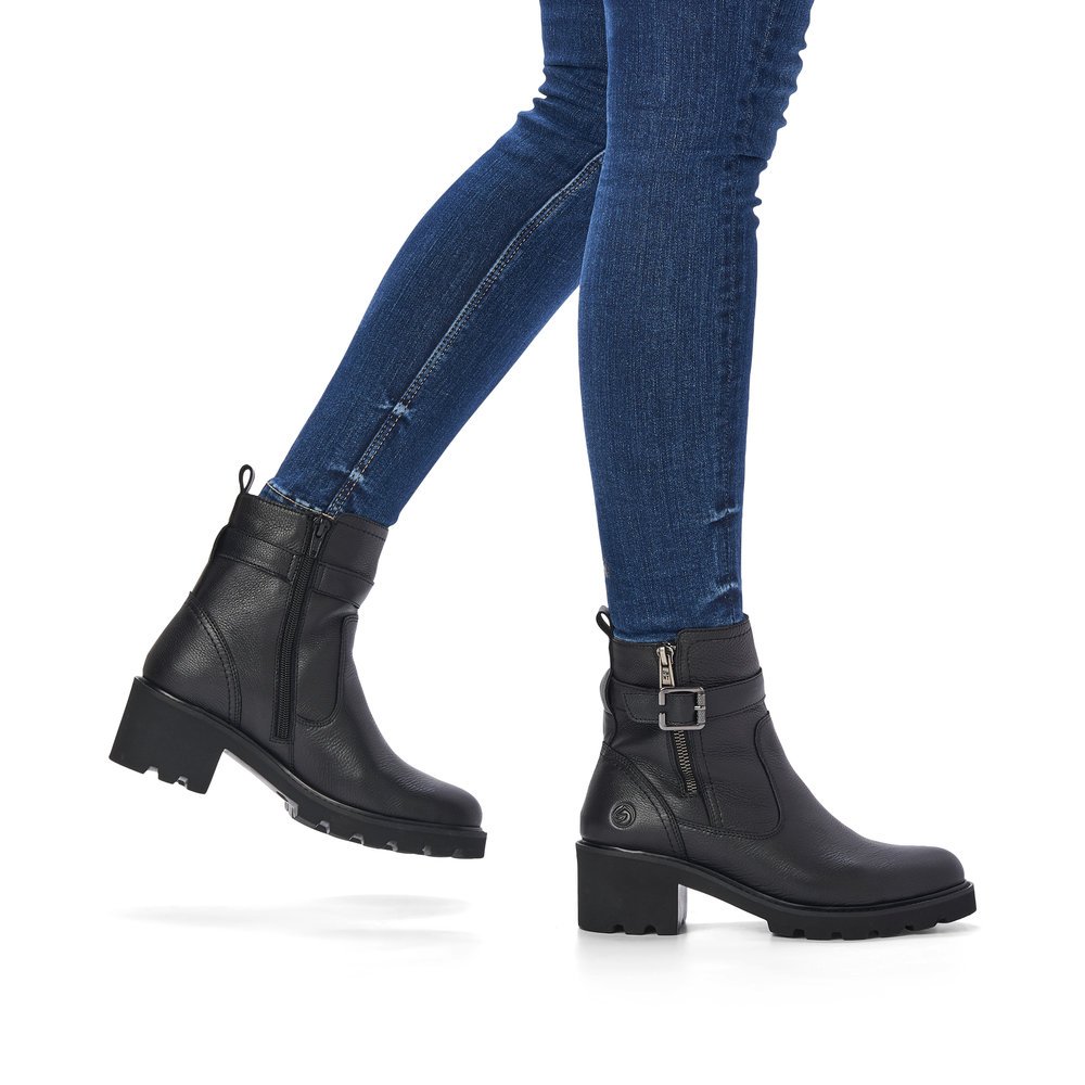 Black remonte women´s biker boots D0A71-01 with decorative buckle as well as zipper. Shoe on foot.