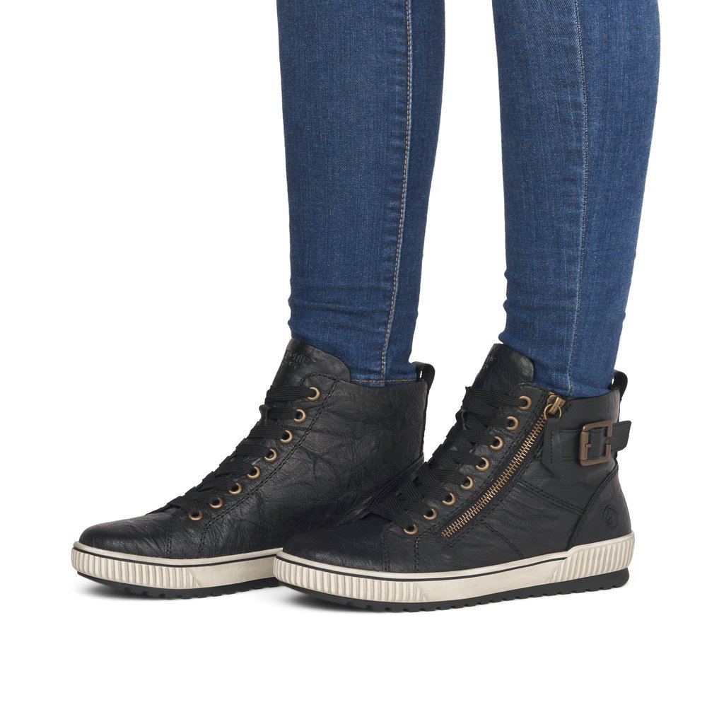 Jet black remonte women´s lace-up boots D0777-01 with a decorative buckle. Shoe on foot.