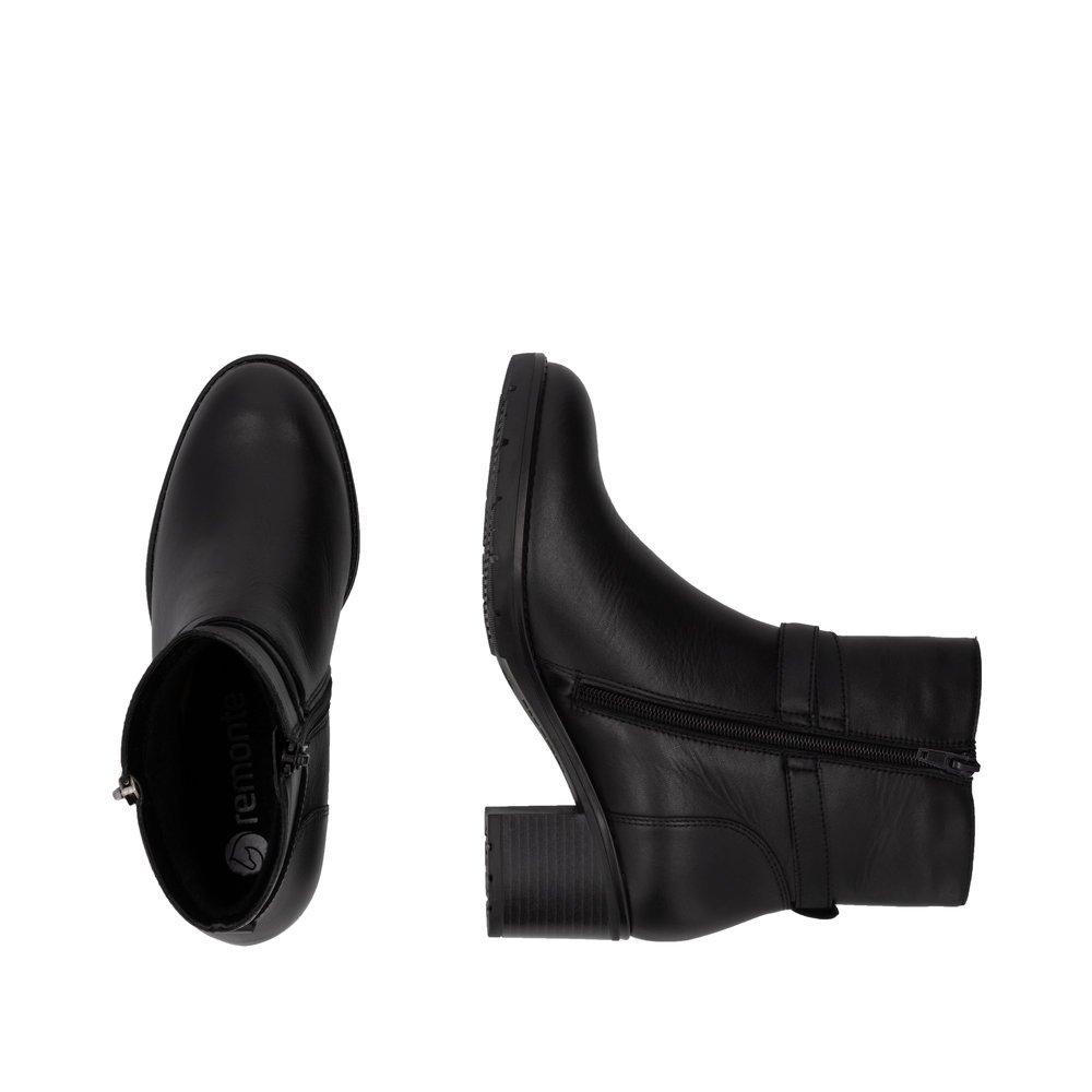 Black remonte women´s ankle boots D2A72-00 with decorative buckle as well as zipper. Shoe from the top, lying.