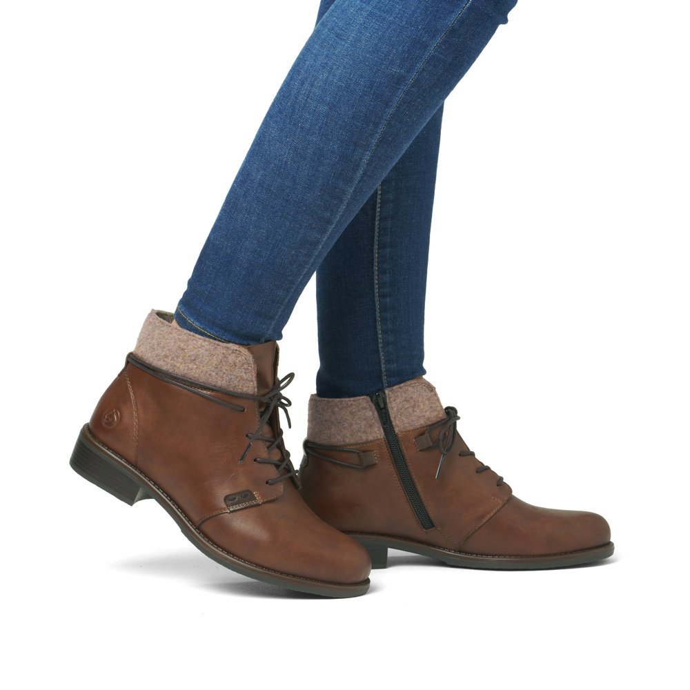 Brown remonte women´s ankle boots D0F78-22 with a shaft collar as well as a zipper. Shoe on foot.