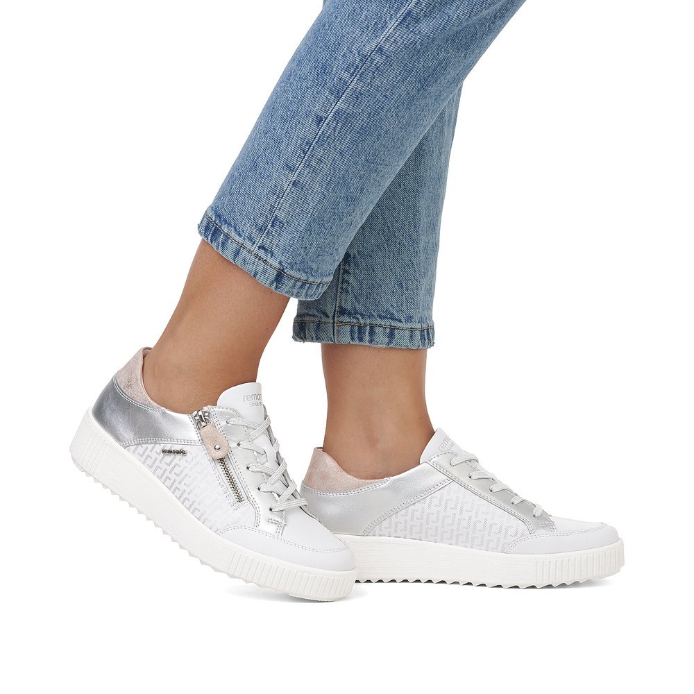 Frost white remonte women´s sneakers R7901-81 with zipper and graphical pattern. Shoe on foot.
