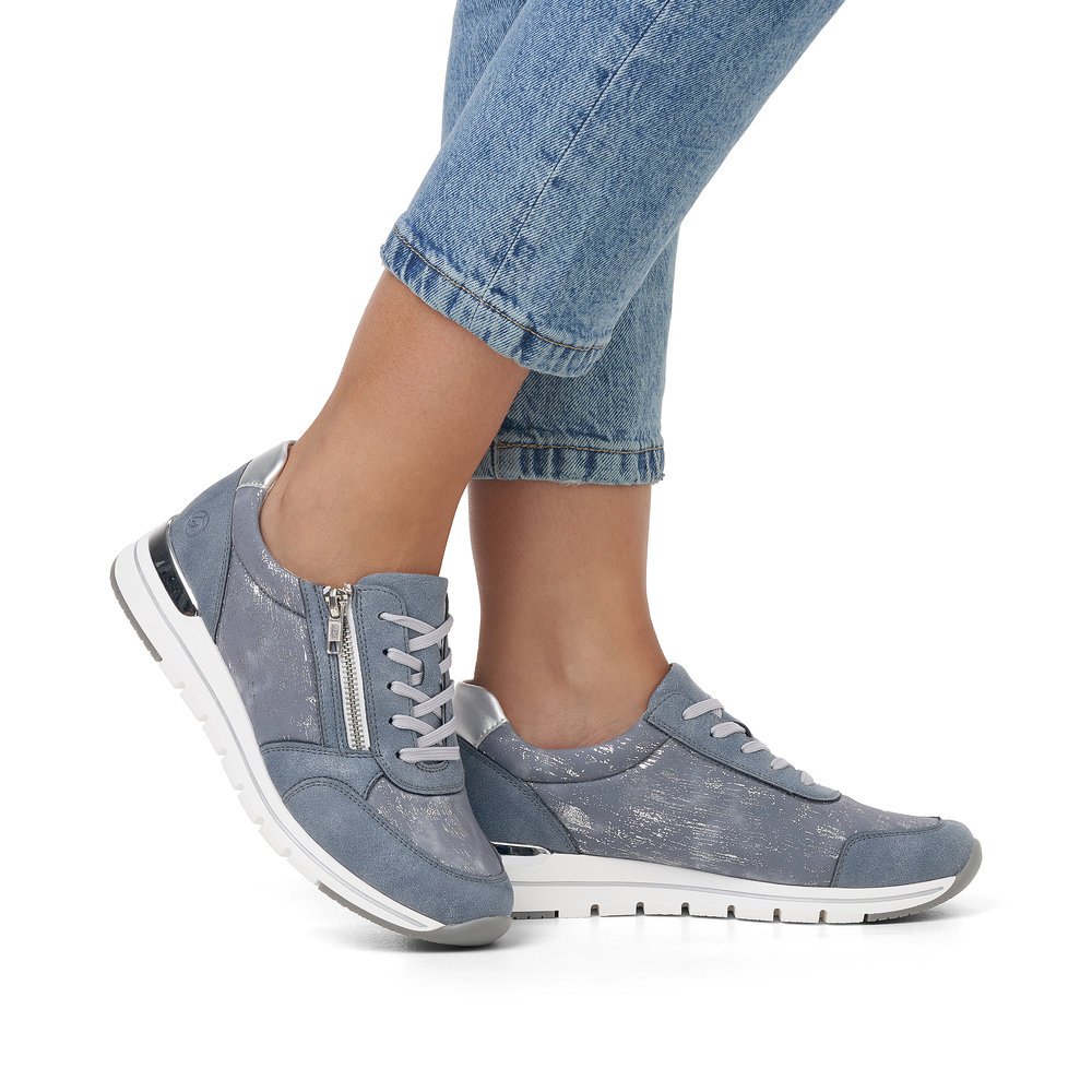 Blue remonte women´s sneakers R6700-13 with zipper and washed-out pattern. Shoe on foot.