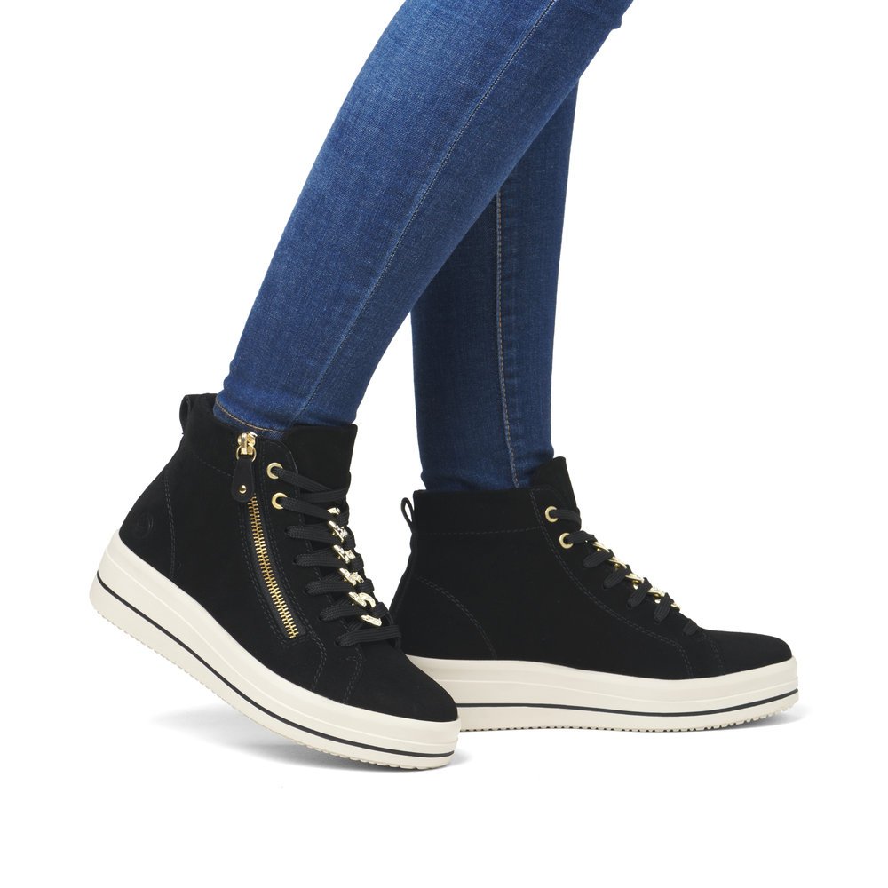 Jet black remonte women´s sneakers D1C70-02 with a chain element as well as zipper. Shoe on foot.