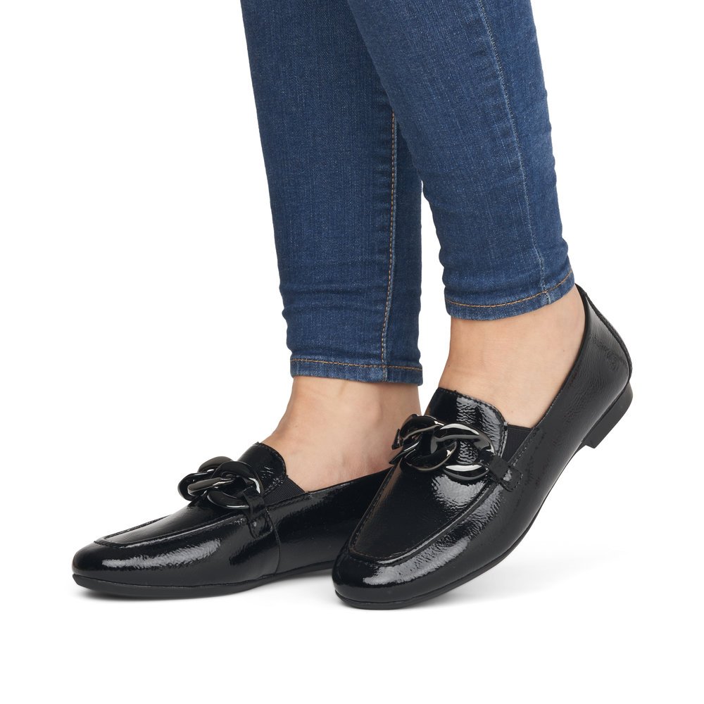 Glossy black remonte women´s loafers D0K00-01 with a chunky chain element. Shoe on foot.