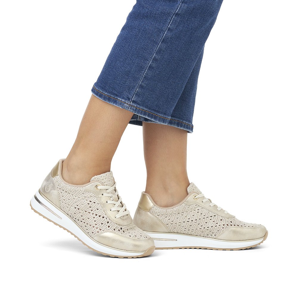 Beige remonte women´s sneakers D1G04-60 with a lacing and perforated look. Shoe on foot.