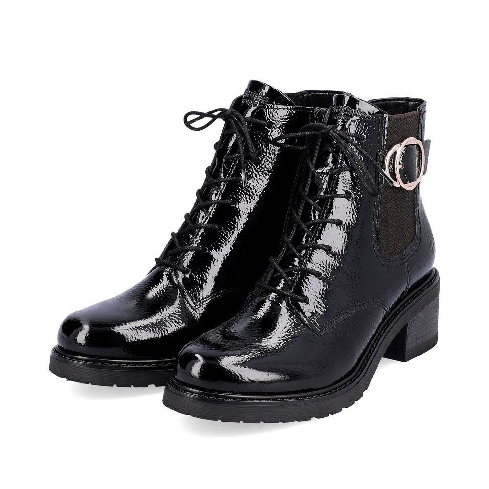 Glossy black remonte women´s biker boots D1A72-01 with a round decorative buckle. Shoes laterally.