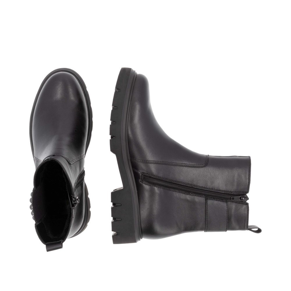 Jet black remonte women´s Chelsea boots D1W74-00 with a round decorative buckle. Shoe from the top, lying.