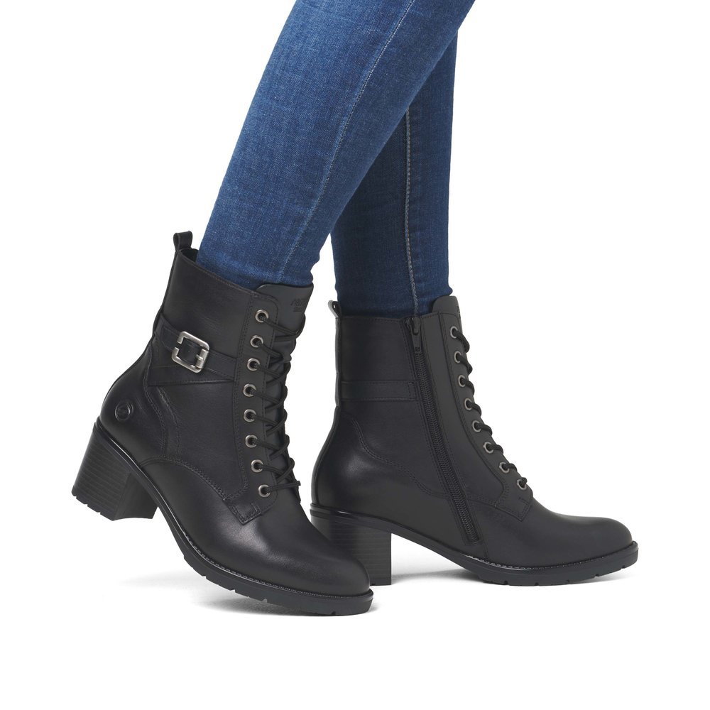 Black remonte women´s ankle boots D2A74-00 with decorative buckle as well as zipper. Shoe on foot.