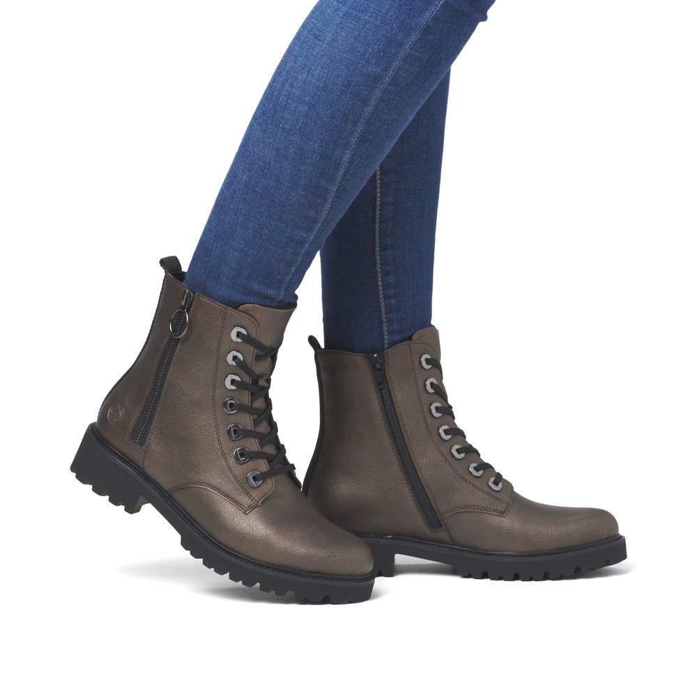 Metallic brown remonte women´s biker boots D8671-92 with a distinctive eyelets. Shoe on foot.