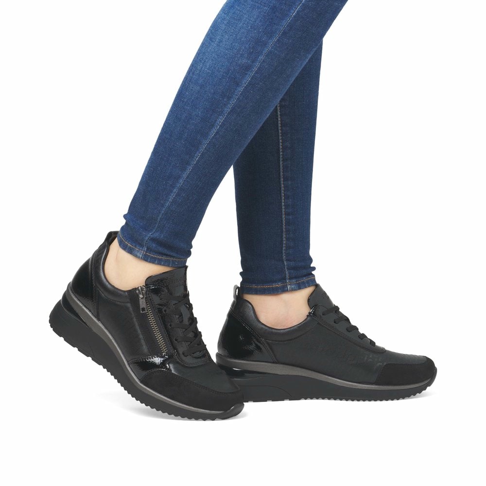 Schwarze remonte Damen Sneaker D2401-06 mit Reißverschluss sowie Komfortweite G. Schuh am Fuß.