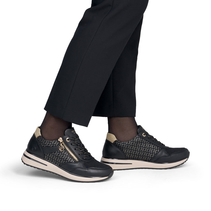 Vegane, schwarze remonte Damen Sneaker D1G08-07 mit goldenen Details. Schuh am Fuß.