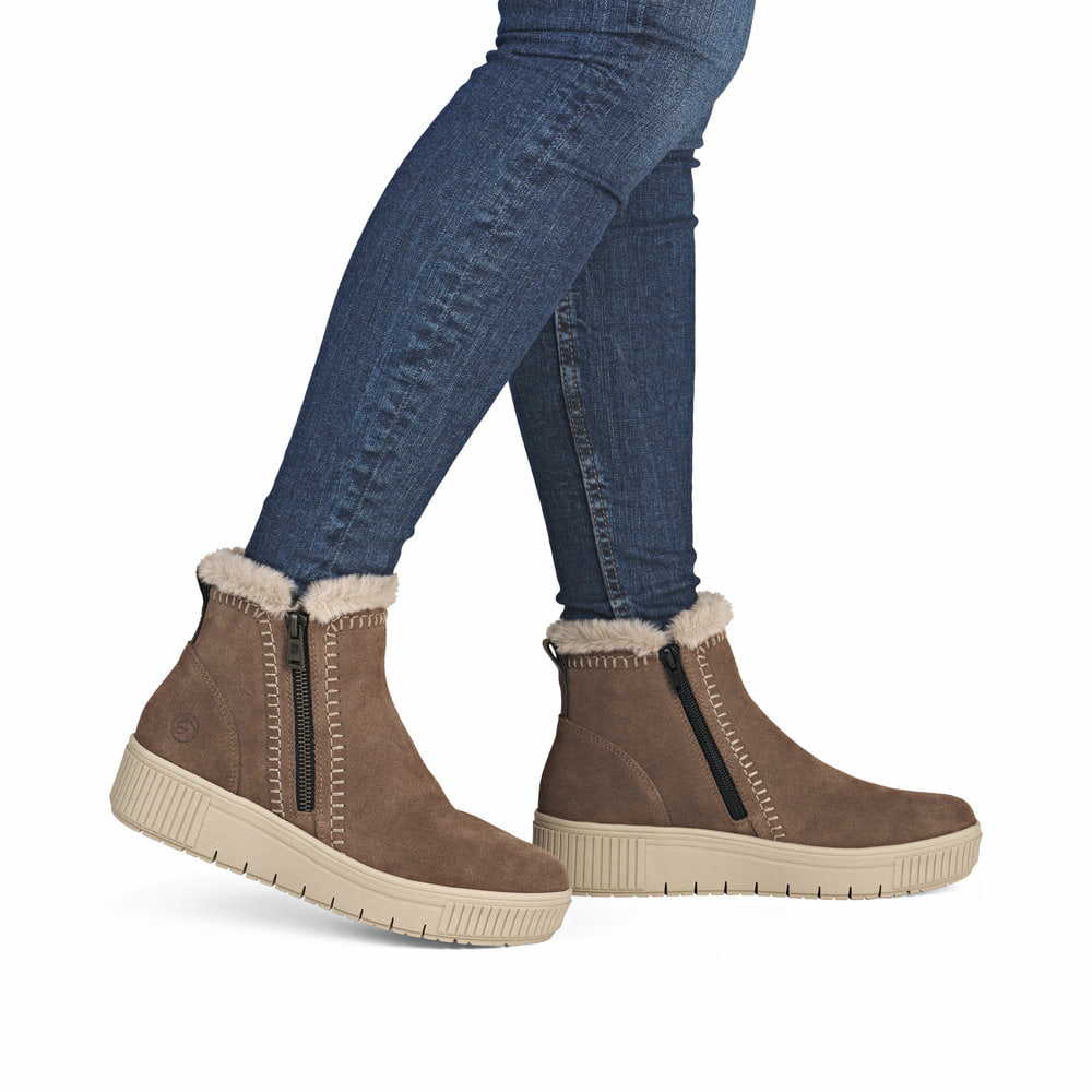 Braunbeige remonte Damen Kurzstiefel D3B70-20 mit weißer Zickzack-Naht. Schuh am Fuß.