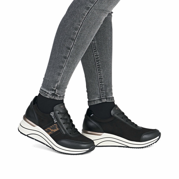 Schwarze remonte Damen Sneaker D0T09-04 mit Leo-Print sowie einem Reißverschluss. Schuh am Fuß.