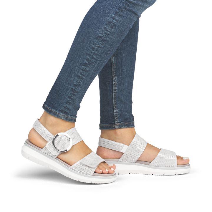 Silberne remonte Keilsandaletten D2K50-91 mit einem Klettverschluss. Schuh am Fuß.