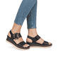 Schwarze remonte Keilsandaletten D2L53-00 mit einem Klettverschluss. Schuh am Fuß.