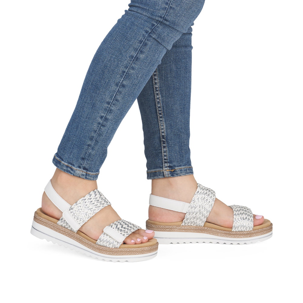 Silberne remonte Keilsandaletten D0Q63-91 mit einem Klettverschluss. Schuh am Fuß.