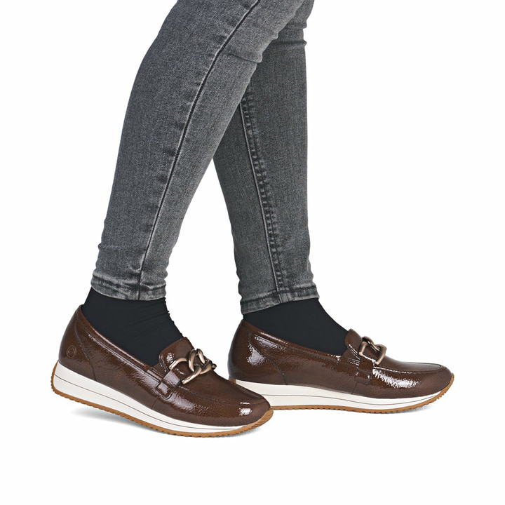 Braune remonte Damen Loafer D0H15-25 mit Deko-Kette sowie einem Gummizug. Schuh am Fuß.