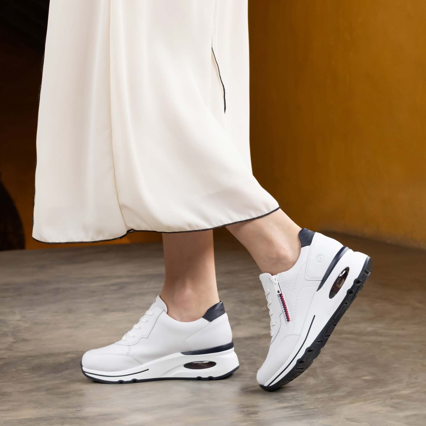 Weiße remonte Damen Sneaker Low D2H00-80 mit Reißverschluss sowie Extraweite H. Schuh am Model.