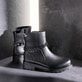 Nachtschwarze remonte Damen Kurzstiefel D2285-00 mit abnehmbarer Kette. Schuhe auf dunklem Hintergrund.