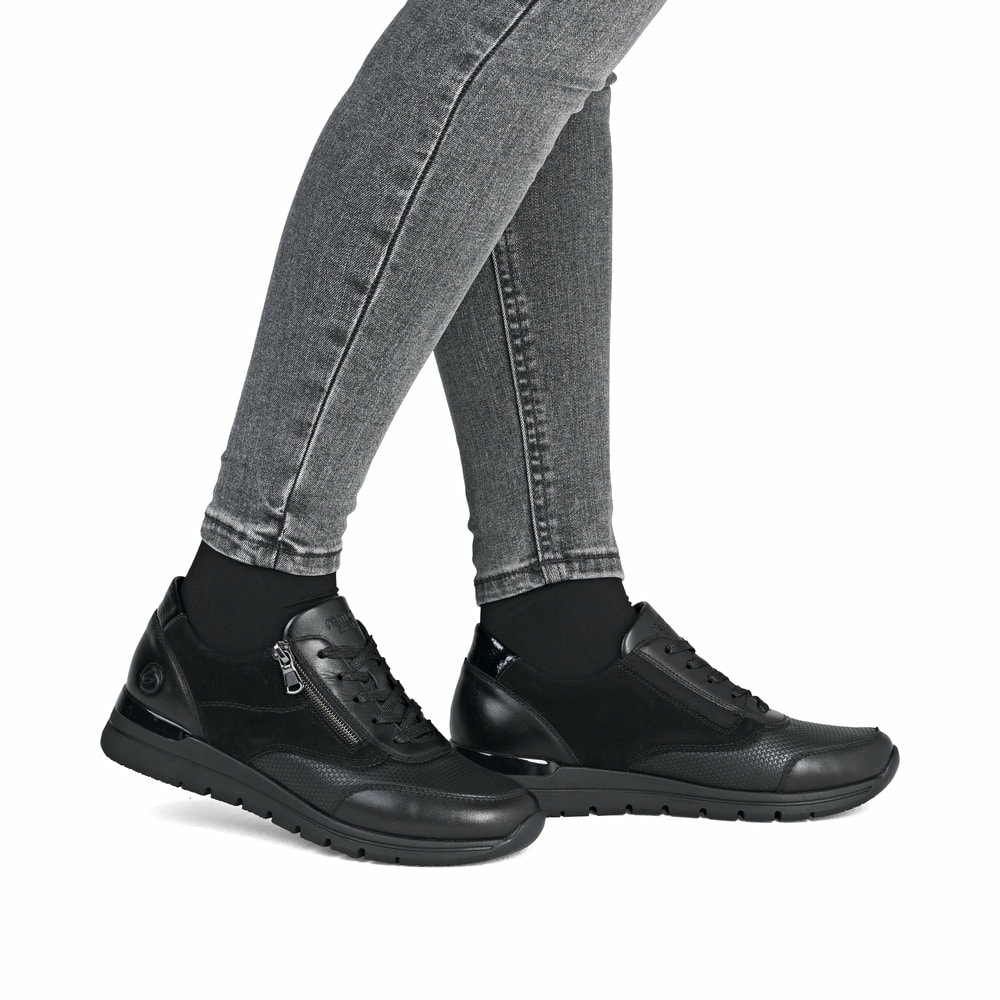 Schwarze remonte Damen Sneaker R6714-02 mit Reißverschluss sowie Komfortweite G. Schuh am Fuß.