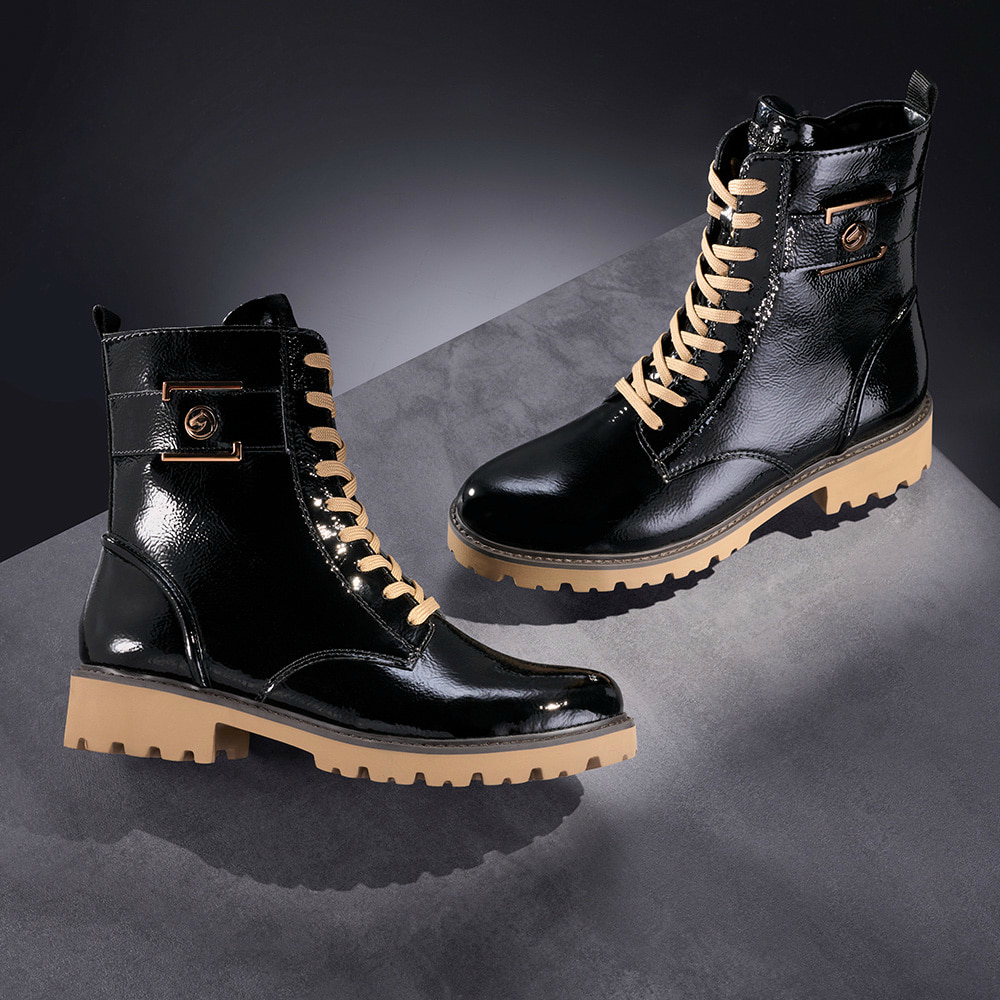 Glanzschwarze remonte Damen Schnürstiefel D8663-00 mit bronzenem Schmuckelement. Schuhe auf dunklem Hintergrund.