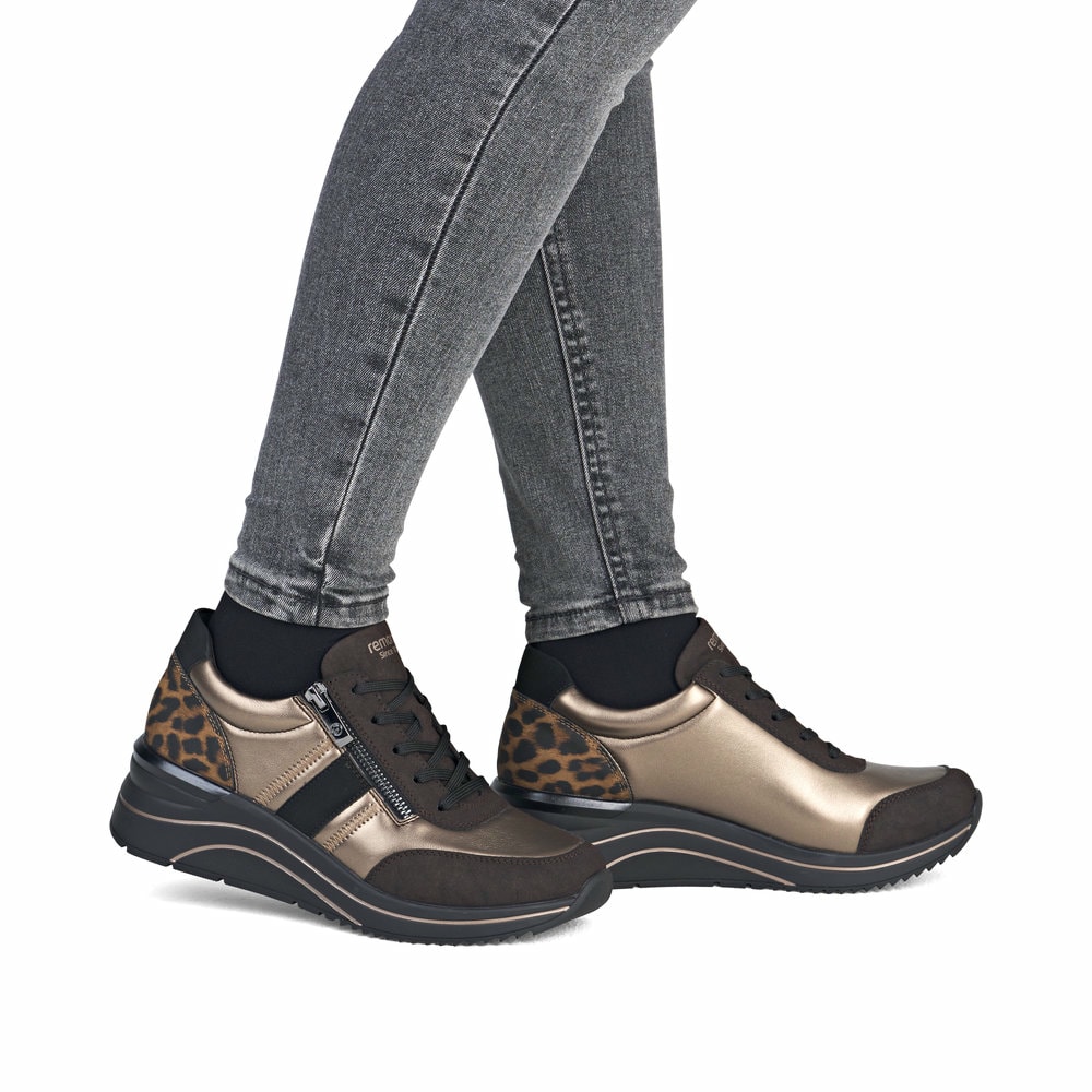 Braunbronzene remonte Damen Sneaker D0T09-91 mit Leo-Print sowie Reißverschluss. Schuh am Fuß.