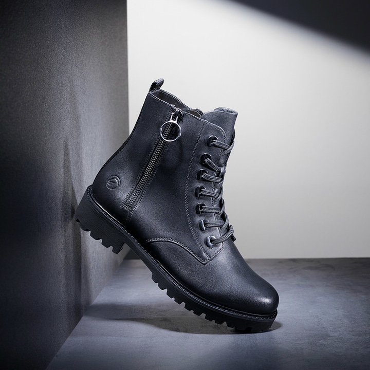 Schwarze remonte Damen Biker Boots D8671-01 mit einer besonders leichten Sohle. Schuh auf dunklem Hintergrund. 
