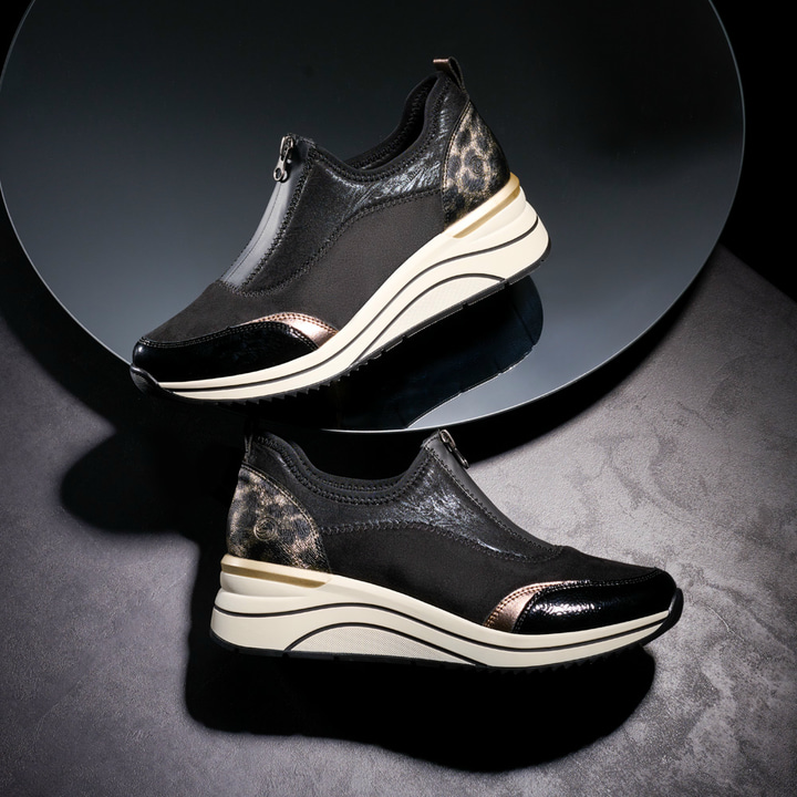 Nachtschwarze vegane remonte Damen Sneaker D0T08-02 mit Animal-Print. Schuhe auf schwarzem Hintergrund.