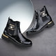 Lackschwarze remonte Chelsea Boots D8684-03 mit goldenem Schmuckelement. Schuhe auf dunklem Hintergrund.