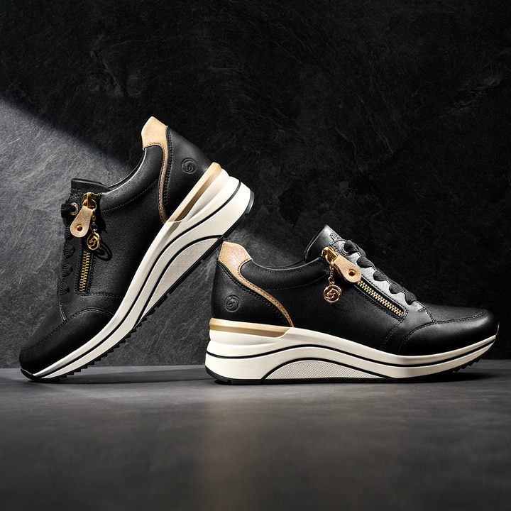 
Steingraue remonte Damen Sneaker D0T01-42 mit einer leichten Sohle mit Keilabsatz. Schuh seitlich schräg