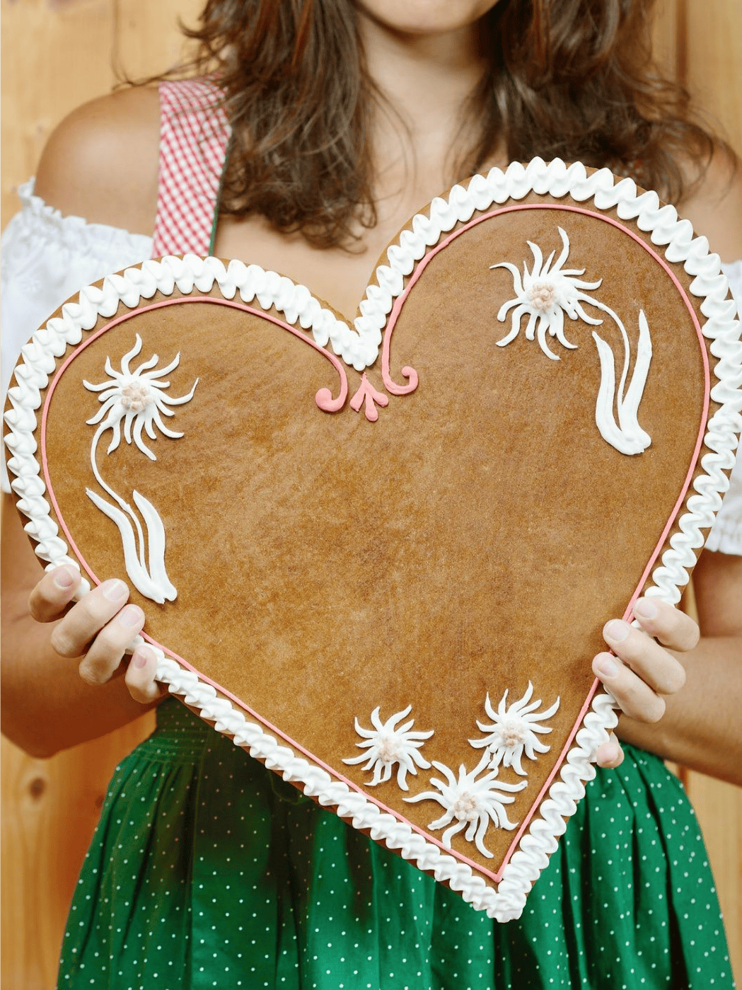 Frau im Dirndl hält ein Lebkuchenherz mit der Aufschrift: \